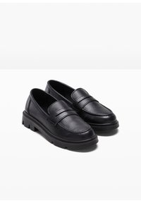 Mocassins en cuir noir avec une finition lisse, présentent deux courroies à l'avant et une semelle en caoutchouc épaisse. Bout arrondi et détails cousus.