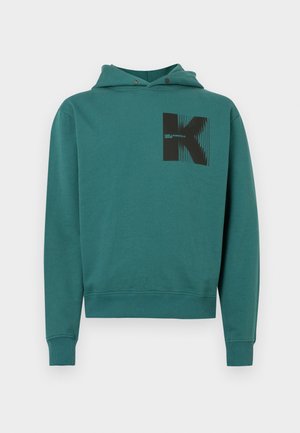 Teal huppari, joka on valmistettu puuvillasekoitteesta. Siinä on kenguru-tasku, kiristettävä huppu, ribbireunukset ja musta graafinen kuvio edessä.