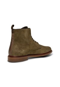 Stivale alla caviglia verde in suede con tacco in pelle liscia marrone e finitura texturizzata. Presenta un davanti con lacci e una robusta suola in legno.