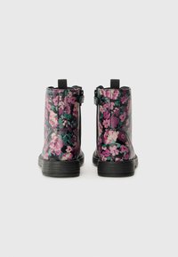 Botas de tobillo florales con un acabado brillante, que presentan una base negra, patrones de flores en rosa y verde, cremalleras y suelas texturizadas.