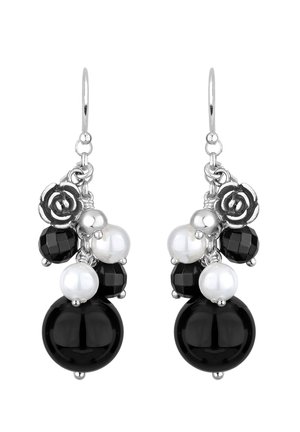 Boucles d'oreilles à crochet argenté avec un assortiment de perles rondes noires et blanches, comprenant des perles noires facettées, des perles blanches lisses et des breloques argentées en forme de rose.