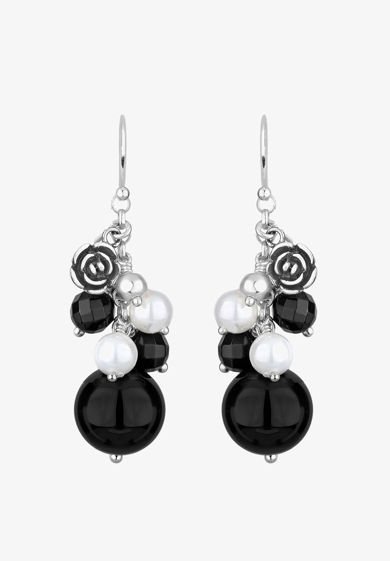 Boucles d'oreilles à crochet argenté avec un assortiment de perles rondes noires et blanches, comprenant des perles noires facettées, des perles blanches lisses et des breloques argentées en forme de rose.