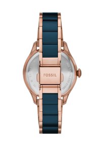 Montre Fossil avec un boîtier en acier inoxydable rose doré et un bracelet en silicone bleu. Dispose d'une fermeture à boucle et d'un fond de boîte transparent.