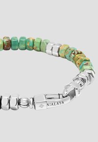Beaded bracelet composed of turquoise and silver, featuring rectangular and hexagonal beads with a clasp marked "NIALAYA."