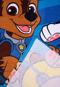 Coperte colorate per bambini con personaggi dei cartoni animati. Una presenta un cane marrone con grandi occhi e un distintivo blu; l'altra ha un design in tonalità pastello chiare.
