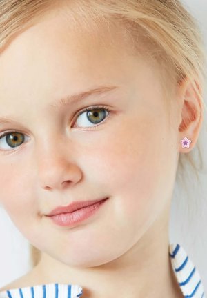 Roze stervormige oorbel met een gelaagd ontwerp, gedragen in het linkeroor van een kind. Het haar van het kind is lichtblond en ze hebben een zacht gezicht.
