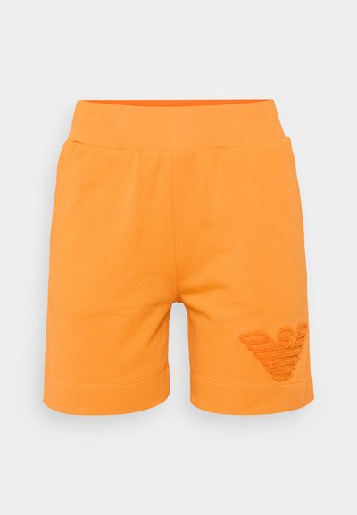 Orange cotton shorts with a textured logo on the right side, featuring an elastic waistband and a straight cut. Smooth texture throughout.
