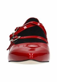 Rode gepatineerde leren schoenen met een ronde neus en twee kruisende banden, voorzien van metallic gespen en een gladde, glanzende afwerking.