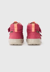 Różowe wysokie buty na rzepy, z gumową podeszwą i textured wykończeniem. Pomarańczowe akcenty z tyłu zwiększają widoczność.