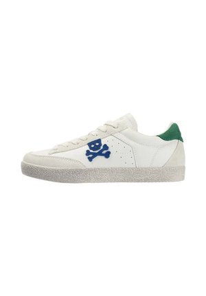 Zapatilla blanca baja con suela texturizada, logo azul de calavera y huesos cruzados en el lateral, y lengüeta verde en el talón.
