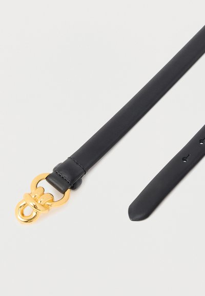 Ceinture en cuir noir avec une boucle en métal doré, présentant une boucle cousue et des trous de réglage sur un fond blanc.