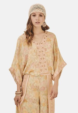 Top ligero de tono pastel con estampado floral, escote en V, mangas oversize y botones decorativos. Combina con pantalones florales a juego.