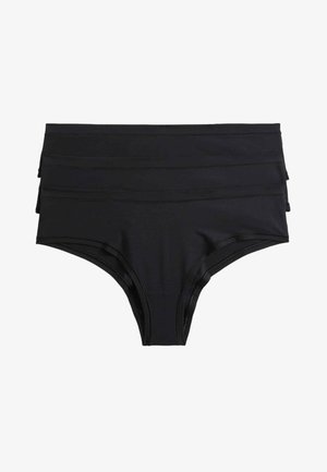 Kobieta w czarnych spodenkach od bikini i czarnym topie, widziana od talii do górnej części ud na białym tle.