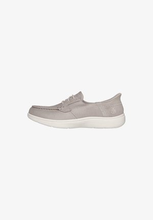 Zapato gris tipo slip-on hecho de tela suave, con una suela blanca acolchada, costuras decorativas y un logo sutil en el costado.