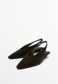 Ballerine slingback in suede nero con punta appuntita e tacchi bassi, esposte su uno sfondo bianco.