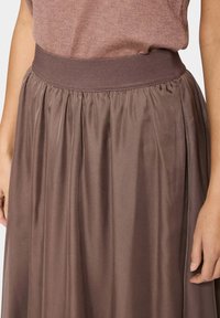 Brauer Satinrock mit einem breiten elastischen Bund, der sanfte Falten für ein fließendes Design aufweist. Glatte Textur und schlichte Eleganz.