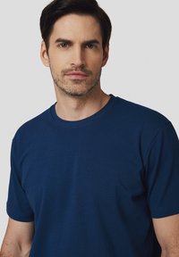 Granatowa, krótki rękaw, koszulka wykonana z bawełny. Okrągły dekolt, gładka tekstura, minimalny design, dopasowany krój. Brak widocznych wzorów lub akcentów.