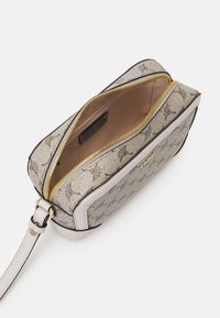 Rits clutch bag in beige, met een gestructureerde stof en een bloemenpatroon, gouden rits, en een gladde lichtroze leren afwerking. Interieur is lichtbruin.