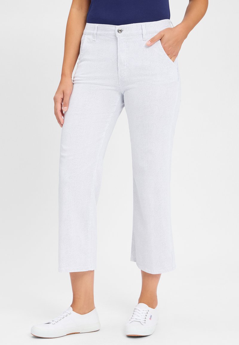 Witte gestreepte cropped broek met een aansluitende taille, voorzakken en een rechte pijpstijl, gecombineerd met witte sneakers.