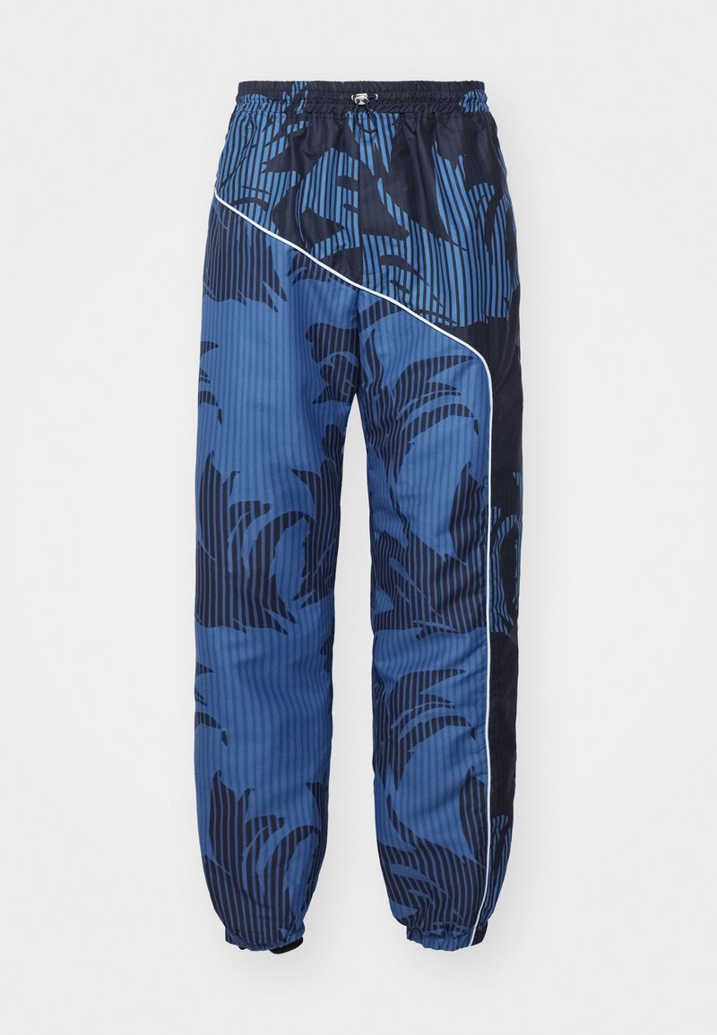 Blauwe joggers met een patroon in een mix van effen en gestreepte texturen, elastische tailleband en trekkoord, met witte piping langs de zijkant.