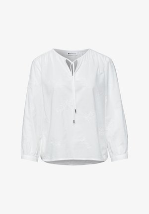 Hvid bluse med lange ærmer med diskret blomsterbroderi, nøglehulshalsudskæring og bindebånd foran, med opsamlede manchetter og en let rundet kant.