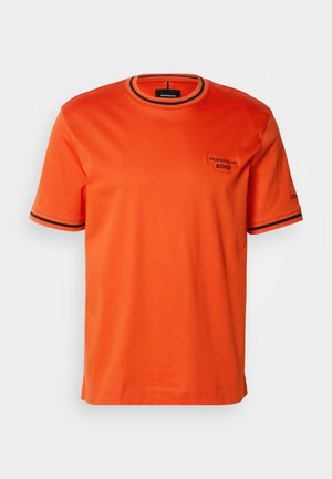 Orange bomullströja med rund halsringning, ribbade detaljer och kontrasterande mörka ränder på ärmarna. Har "Porsche" och "BOSS" logotyper.