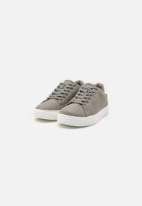 Gray suede sneakers with white rubber soles, flat laces, and minimalistic design. Features a smooth texture and reinforced stitching.