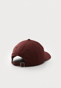 Justerbar marsala baseball cap med bøyd skjerm, stoffmateriale, brodert detalj "EST 1922" bak, og stropplukking.