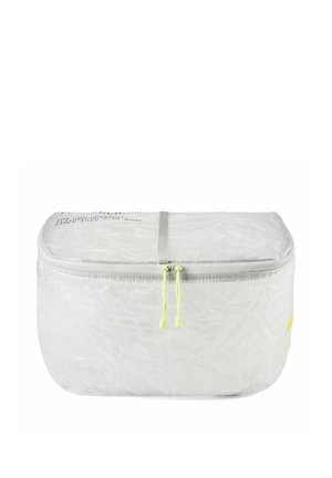 Pochette compatta bianca con zip, due cursori giallo neon e testo stampato sottile in cima su sfondo bianco.