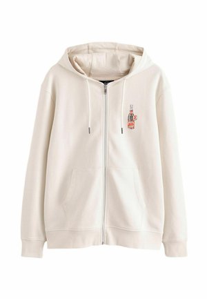 Cremefarvet hættejakke med lynlås, frontlommer, hætte med snore og en lille broderet vintage sodaflaske på venstre bryst.
