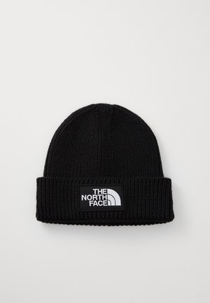 Bonnet en tricot noir avec un revers, doté d'un patch logo rectangulaire affichant "The North Face" en blanc sur fond noir.