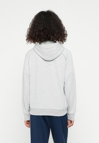 Gray hooded sweatshirt with a relaxed fit, raglan sleeves, and ribbed hem. Fabric appears soft-textured and casual in design.