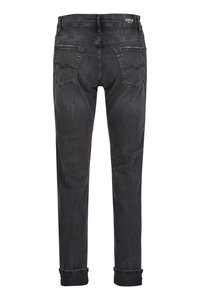 Zwarte denim jeans met een taps toelopende pijp, subtiele vervaging, twee achterzakken en omgeslagen mouwen. Kenmerkend is het merklabel op de tailleband.