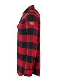 Chemise en flanelle à carreaux rouges et noirs à manches longues avec poches poitrine boutonnées et petit patch rectangulaire sur la manche supérieure.