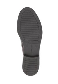 Semelle d'une chaussure en caoutchouc noir texturé, avec des rainures horizontales pour une meilleure adhérence et un léger talon. Logo imprimé et détails de taille présents.