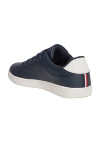 Sneaker blu navy in materiale sintetico liscio, suola in gomma bianca e un accentuazione bianca sul tallone con strisce rosse e blu.