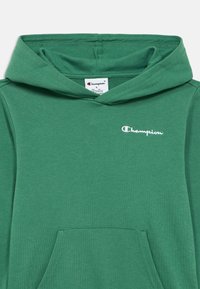 Φούτερ με κουκούλα Green Champion από απαλό ύφασμα. Διαθέτει τσέπη καγκουρό, κουκούλα με κορδόνι και λευκό κεντημένο λογότυπο στο στήθος.