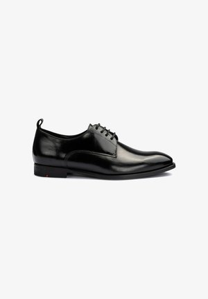 Chaussure habillée pour homme en cuir noir poli avec laçage à l'avant, bout arrondi et petit talon sur fond blanc.