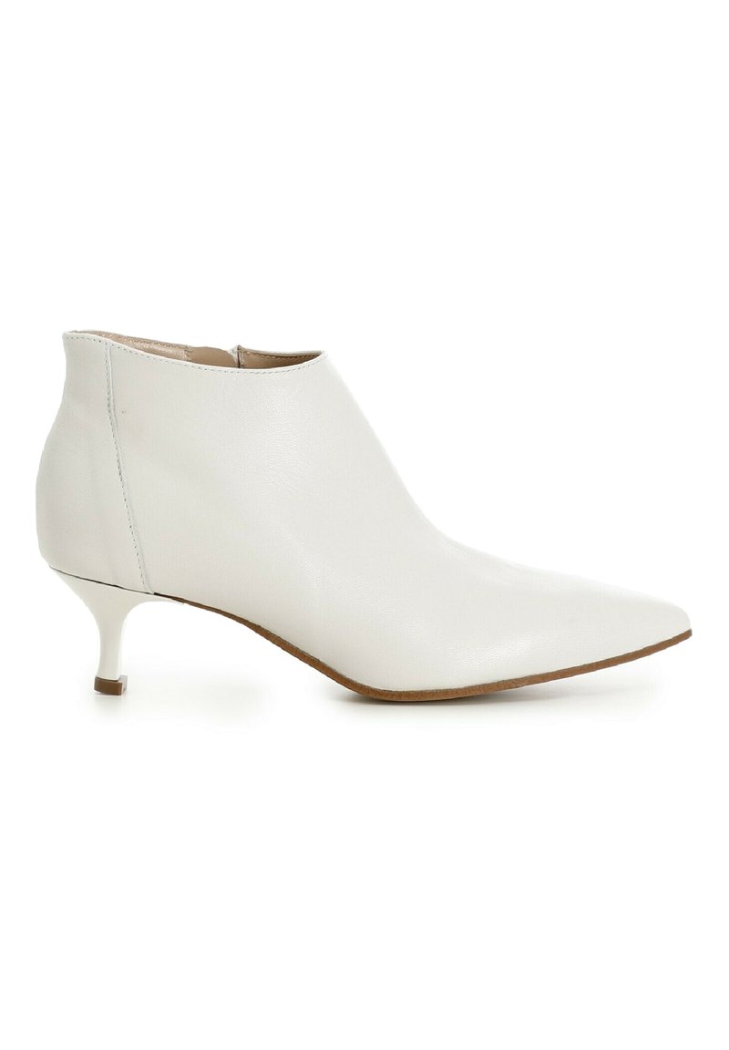 Botte de cheville en cuir blanc avec un bout pointu, un petit talon et une texture lisse. Présente un design minimaliste sans quincaillerie visible.