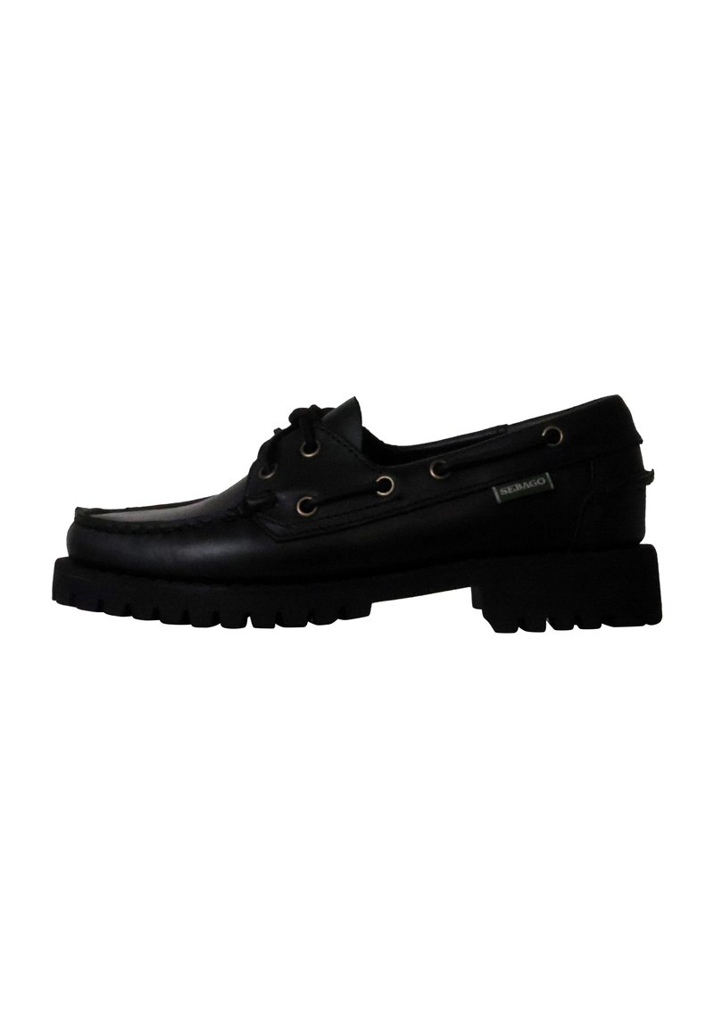 Scarpa da barca in pelle nera con punta arrotondata, lati perforati e suola in gomma spessa. Presenta occhielli dorati e un'etichetta del marchio laterale.