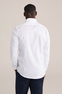 Witte lange mouwen blouse met een rechte kraag, gladde textuur en een afgeronde zoom, voorzien van knoopdetails op de manchetten.