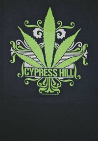 Zwarte t-shirt met een levendige groene grafiek van een gestileerd cannabisblad met sierlijke details en de tekst "CYPRESS HILL" in vette letters.