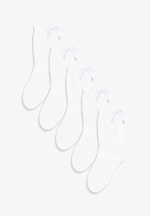 Valkoiset nilkkasukat, jotka on valmistettu pehmeästä materiaalista ja joissa on koristeellinen nauha varressa. Viiden parin setti. Sileä pinta.