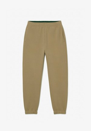 Beżowe spodnie dresowe z elastycznym paskiem w talii, kieszeniami bocznymi i elastycznymi mankietami. Wykonane z miękkiego materiału o gładkiej fakturze.