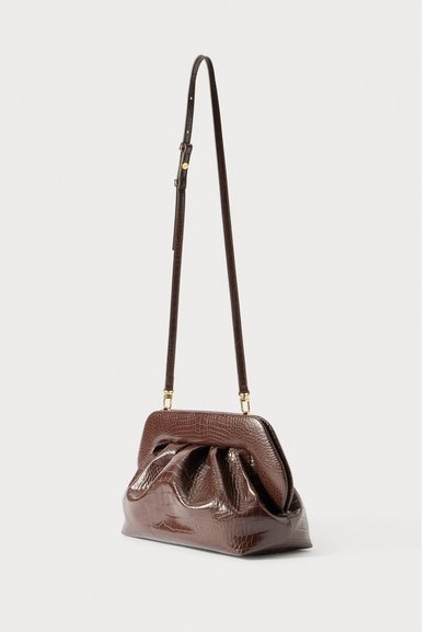 Bolsa de ombro em pele de crocodilo de tom castanho escuro com um design frontal franzido e alça fina ajustável, apresentada contra um fundo simples.