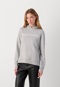 Grau Hoodie aus weichem Stoff mit einer Kängurutasche und einem großen, weißen „Marc O'Polo“-Logo auf der Brust.