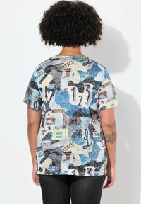 Multifarvet grafisk T-shirt med en blanding af blå, sort og beige mønstre samt tekst-elementer; korte ærmer og rund halsudskæring.
