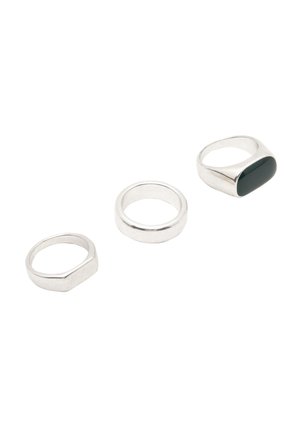 Three rings: one hexagonal silver band, one smooth silver band, and one silver ring with an elongated dark green stone.