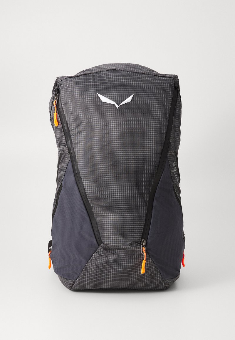 Sac à dos avec un motif de grille gris foncé, texture en tissu, tirettes de zip orange et un logo blanc à l'avant. Dispose de fermetures éclair sur les côtés et sur le dessus.