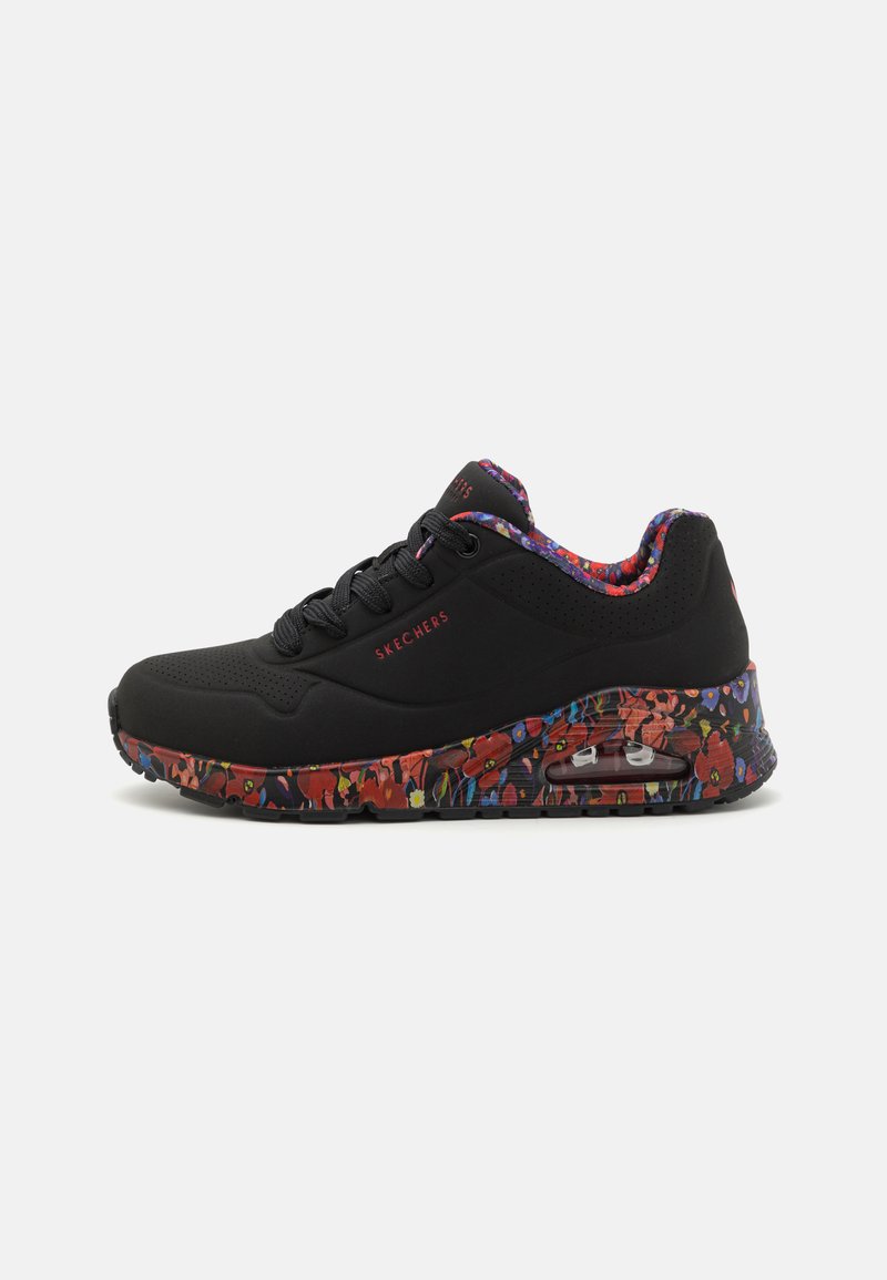 Baskets Skechers noires avec une semelle à motifs floraux, dotées d'un dessus en mesh, d'un col rembourré, d'un système de laçage et d'un coussin d'air visible.